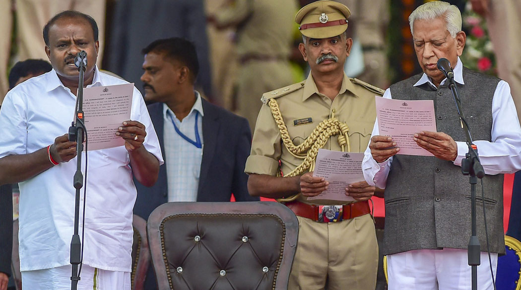 Opposition leader on the stage of the swearing-in by Kumaraswamy